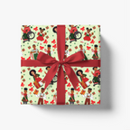 A square gift box wrapped in festive wrapping paper with a repeating pattern of Black children, red bows, and red envelopes on a pale green background, tied with a wide red ribbon and bow, shown on a clean white background.